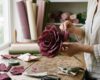 Crafter's hands shaping realistic burgundy crepe paper petals for giant flowers